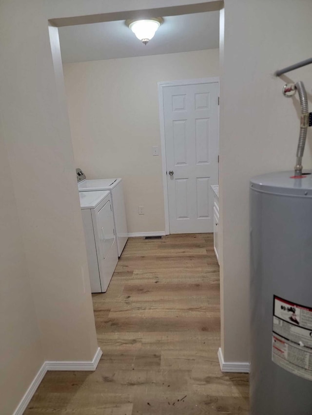 640 Cooks Knob Rd, Ferrum, VA 24088 - laundry room featuring electric water heater, washing machine and dryer, light wood-style flooring, and baseboards