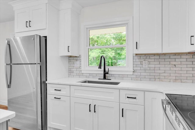 201 Forest Ridge Dr, Vinton, VA 24179 - kitchen with freestanding refrigerator, a sink, decorative backsplash, and white cabinets