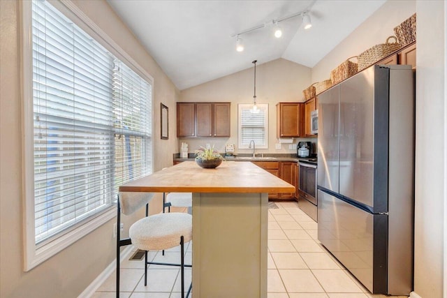 590 Keystone Dr NW, Christiansburg, VA 24073 - kitchen with stainless steel appliances, rail lighting, vaulted ceiling, a breakfast bar, and brown cabinetry