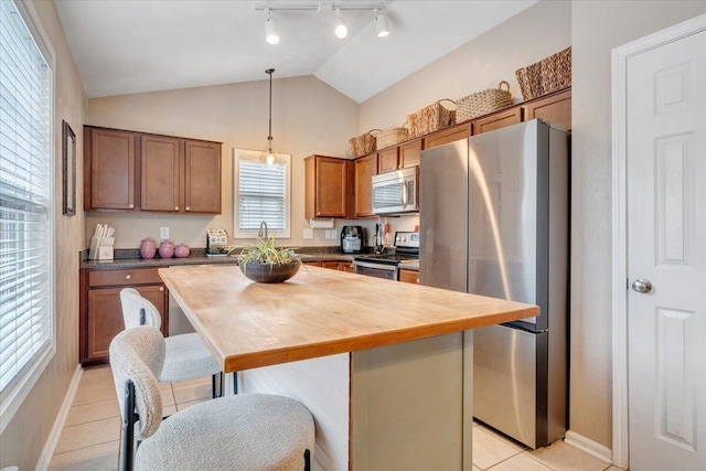 590 Keystone Dr NW, Christiansburg, VA 24073 - kitchen with stainless steel appliances, light tile patterned floors, a breakfast bar area, decorative light fixtures, and a kitchen island