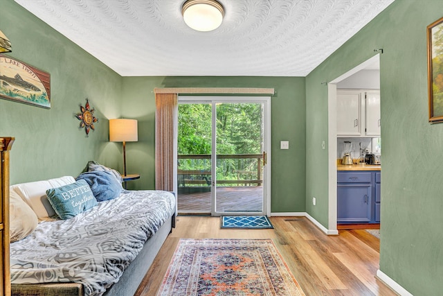 508 Hemlock Shores Dr, Goodview, VA 24095 - bedroom with access to exterior, light wood-style flooring, and bar