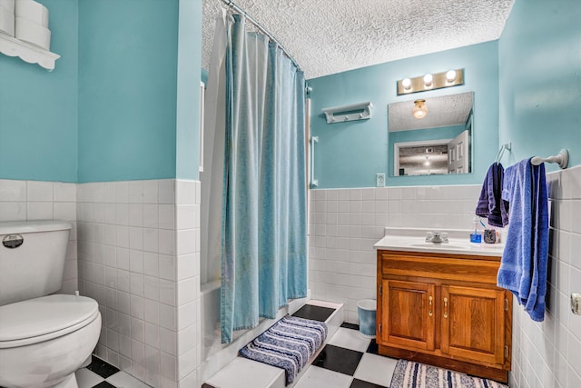 508 Hemlock Shores Dr, Goodview, VA 24095 - bathroom with tile walls, toilet, a wainscoted wall, vanity, and a textured ceiling