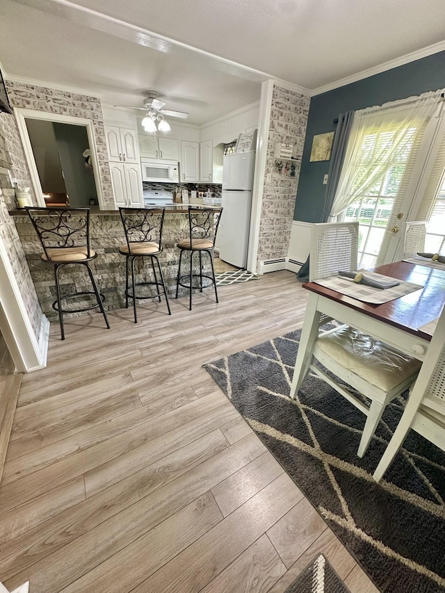 104 Wintergreen Ave, Clifton Forge, VA 24422 - dining room with crown molding, light wood finished floors, and ceiling fan