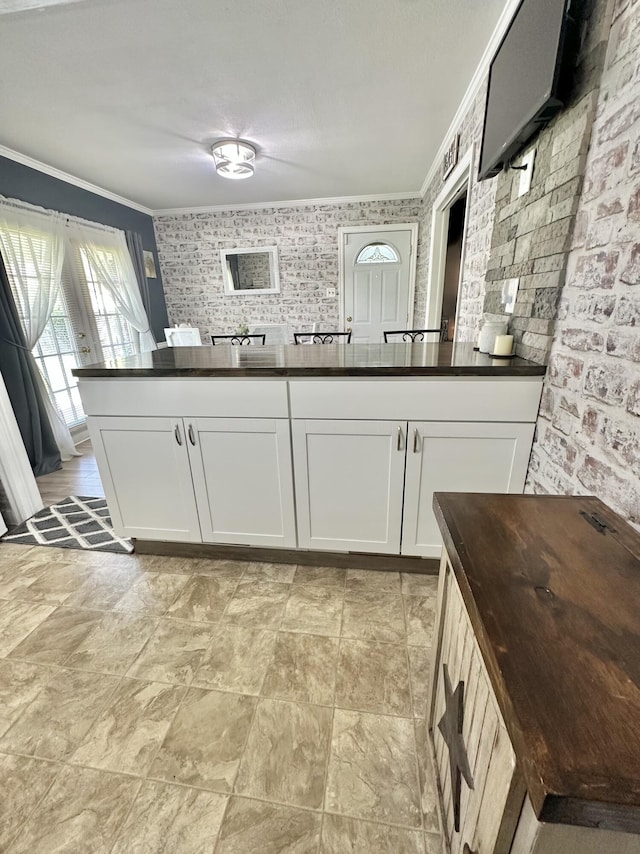 104 Wintergreen Ave, Clifton Forge, VA 24422 - kitchen featuring crown molding, white cabinetry, a peninsula, and light stone finish floors