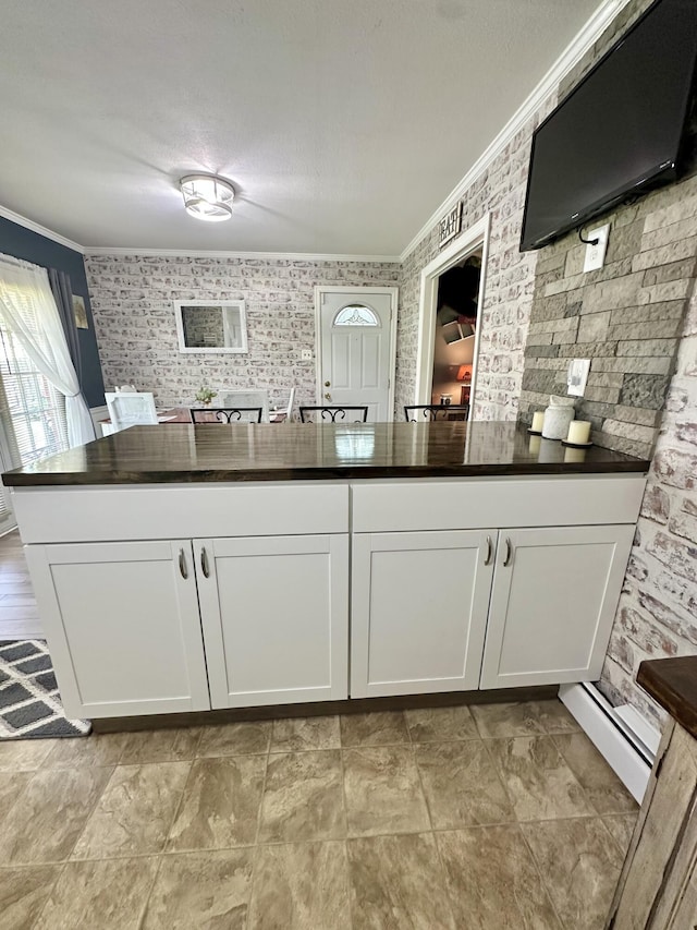 104 Wintergreen Ave, Clifton Forge, VA 24422 - kitchen featuring ornamental molding, white cabinetry, and a baseboard heating unit