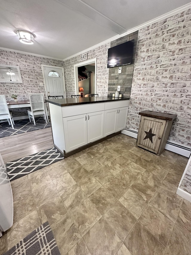 104 Wintergreen Ave, Clifton Forge, VA 24422 - kitchen featuring ornamental molding, a baseboard radiator, dark countertops, white cabinetry, and a peninsula