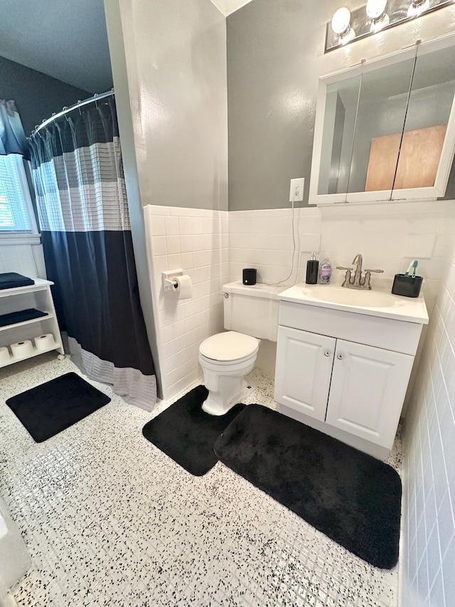 104 Wintergreen Ave, Clifton Forge, VA 24422 - full bath with tile walls, toilet, vanity, a shower with shower curtain, and wainscoting