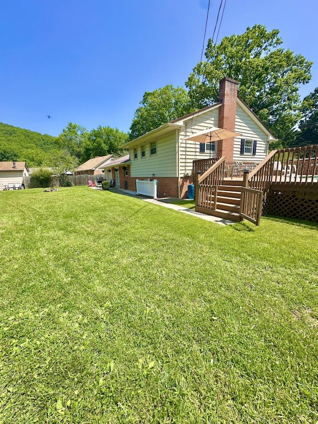 104 Wintergreen Ave, Clifton Forge, VA 24422 - back of property with a wooden deck, a yard, central AC, and a chimney