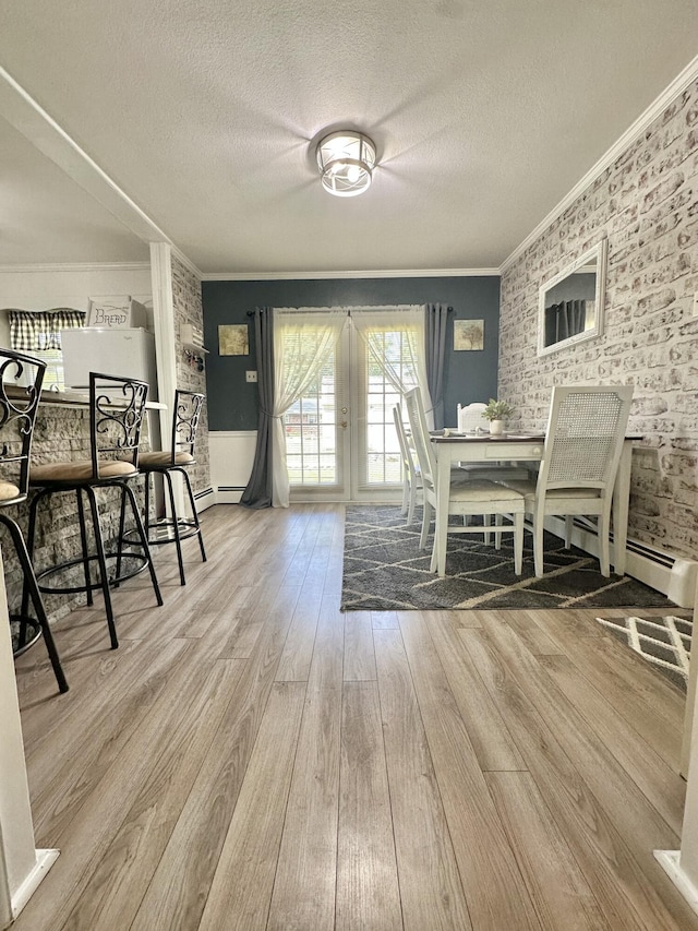 104 Wintergreen Ave, Clifton Forge, VA 24422 - dining area featuring french doors, wood finished floors, crown molding, a textured ceiling, and brick wall