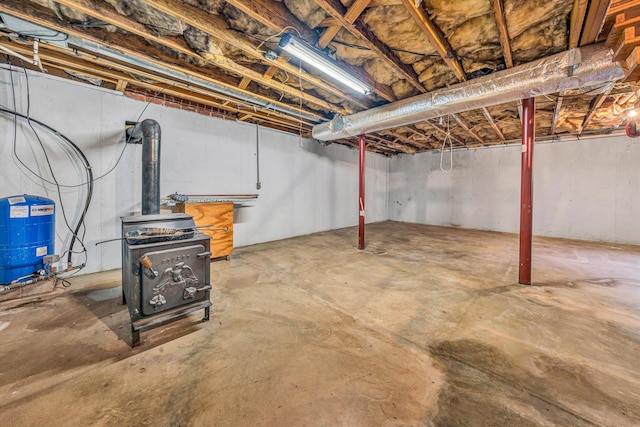 20083 Snow Creek Rd, Penhook, VA 24137 - unfinished below grade area featuring a water pressure tank and a wood stove