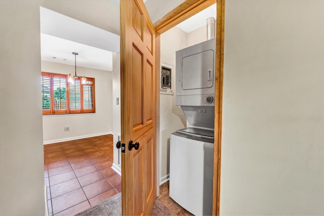 1801 Bluemont Ave SW Unit G, Roanoke, VA 24015 - laundry room with stacked washer / dryer, a chandelier, dark tile patterned flooring, and baseboards