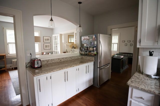 1810 Windsor Ave SW, Roanoke, VA 24015 - kitchen featuring freestanding refrigerator, radiator, dark wood-style floors, arched walkways, and white cabinets