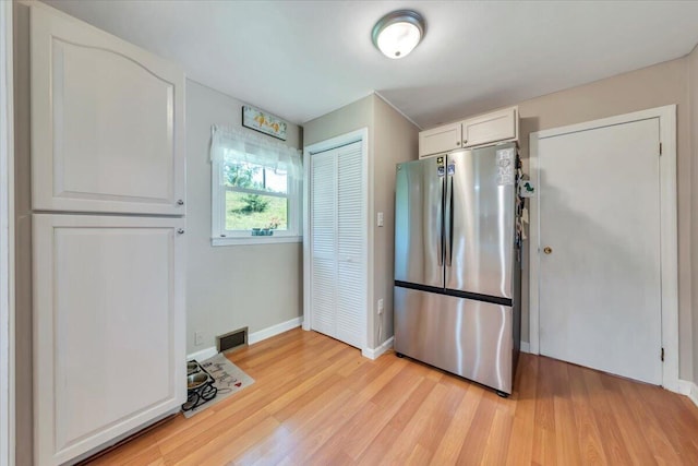 3135 Doe Run Rd, Rocky Mount, VA 24151 - kitchen featuring freestanding refrigerator, light wood-type flooring, baseboards, and white cabinetry