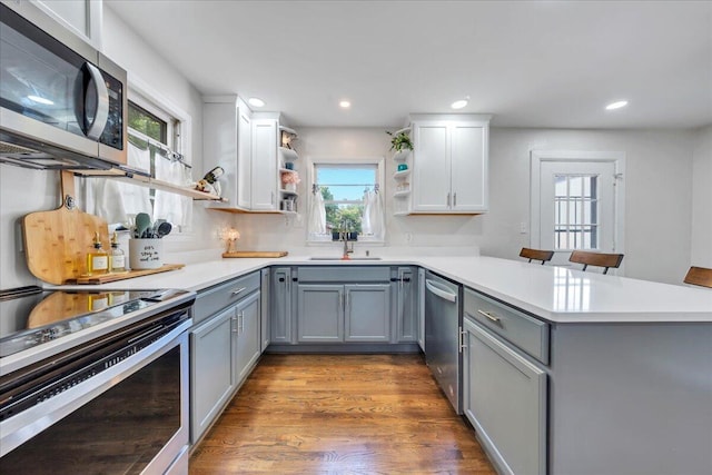 4708 Pawling St NW, Roanoke, VA 24012 - kitchen featuring appliances with stainless steel finishes, gray cabinets, a sink, open shelves, and a peninsula