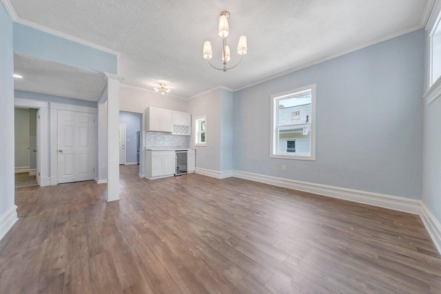 3311 Memorial Ave, Lynchburg, VA 24501 - unfurnished living room featuring wood finished floors, a chandelier, beverage cooler, crown molding, and a textured ceiling