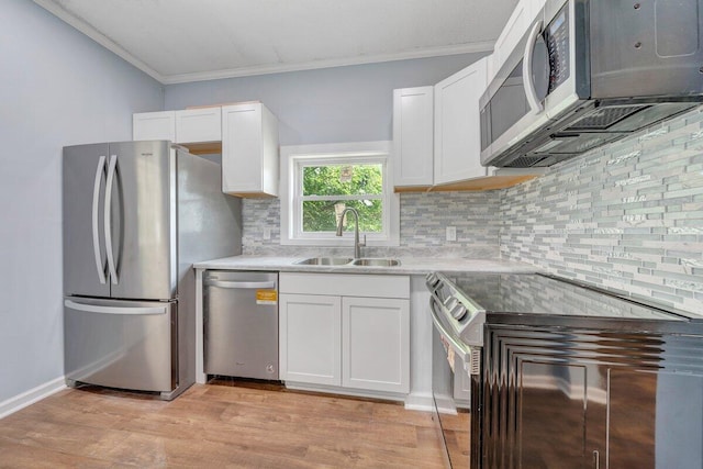 3311 Memorial Ave, Lynchburg, VA 24501 - kitchen featuring appliances with stainless steel finishes, ornamental molding, decorative backsplash, light wood-style flooring, and white cabinets