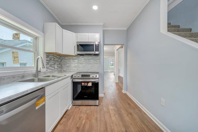 3311 Memorial Ave, Lynchburg, VA 24501 - kitchen with stainless steel appliances, crown molding, light wood-type flooring, tasteful backsplash, and white cabinets