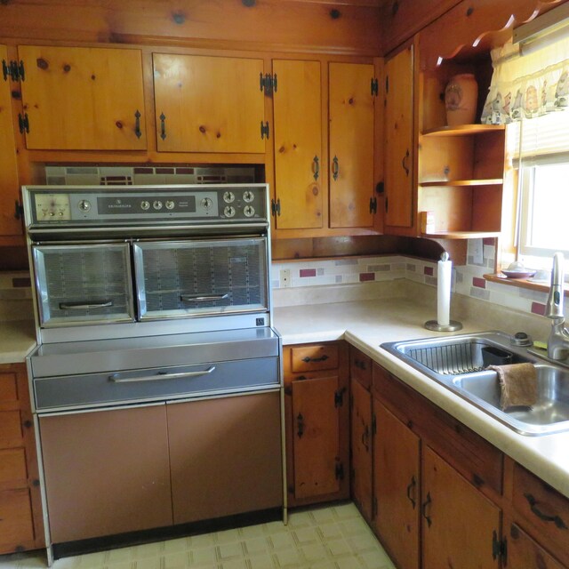 383 Main St, New Castle, VA 24127 - kitchen featuring a sink, stainless steel oven, light countertops, open shelves, and light floors