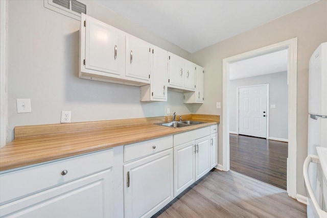 2109 Colgate St NE, Roanoke, VA 24012 - kitchen featuring a sink, white cabinets, light wood-style floors, light countertops, and baseboards