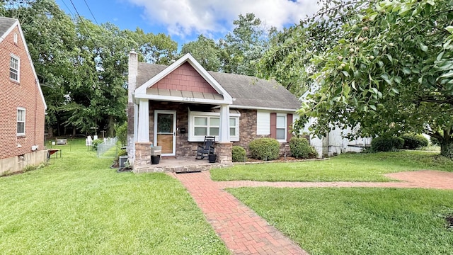 2436 Lofton Rd SW, Roanoke, VA 24015 - craftsman-style house featuring a front lawn, a chimney, roof with shingles, stone siding, and a porch