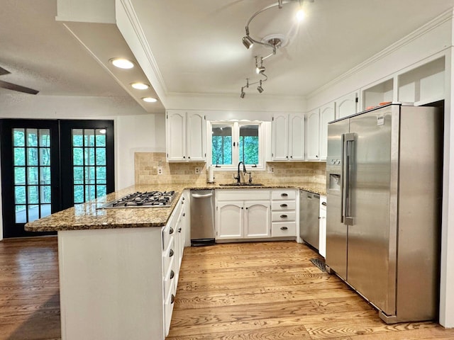 4867 Hunting Hills Dr, Roanoke, VA 24018 - kitchen featuring appliances with stainless steel finishes, a sink, a peninsula, light stone counters, and light wood-style flooring
