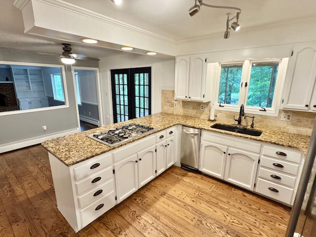 4867 Hunting Hills Dr, Roanoke, VA 24018 - kitchen featuring appliances with stainless steel finishes, a sink, a peninsula, light wood finished floors, and decorative backsplash