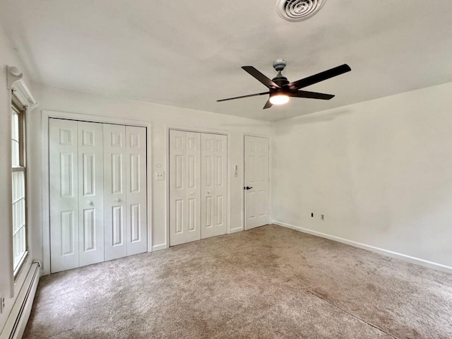 4867 Hunting Hills Dr, Roanoke, VA 24018 - unfurnished bedroom featuring a baseboard heating unit, two closets, carpet floors, and baseboards