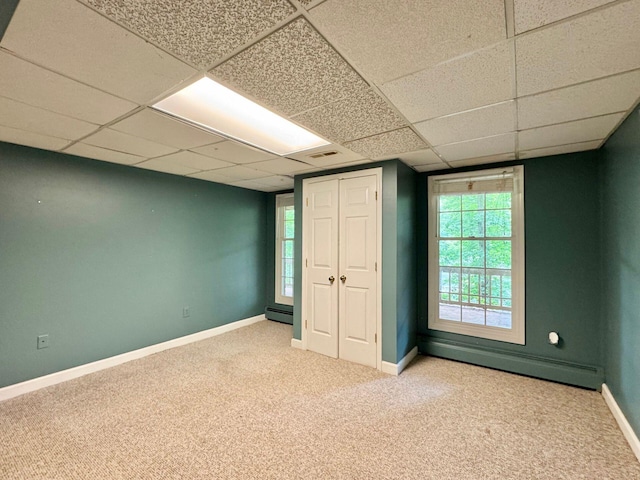 4867 Hunting Hills Dr, Roanoke, VA 24018 - unfurnished bedroom featuring baseboard heating, carpet flooring, baseboards, multiple windows, and a drop ceiling
