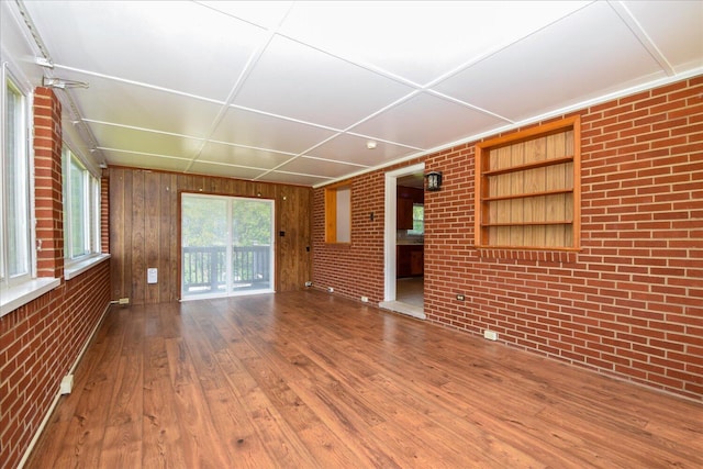 1008 Ridgecrest Dr, Roanoke, VA 24019 - unfurnished living room with brick wall, wood finished floors, and wood walls