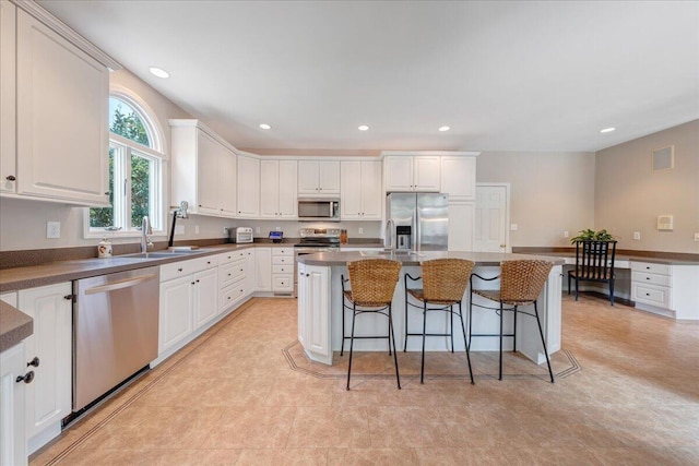 1425 Cravens Creek Ln SW, Roanoke, VA 24018 - kitchen featuring stainless steel appliances, a sink, a kitchen breakfast bar, white cabinetry, and a center island
