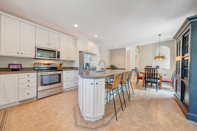 1425 Cravens Creek Ln SW, Roanoke, VA 24018 - kitchen featuring stainless steel appliances, a sink, dark countertops, a kitchen breakfast bar, and decorative light fixtures