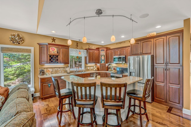 480 Winding Waters Dr, Moneta, VA 24121 - kitchen featuring appliances with stainless steel finishes, a sink, glass insert cabinets, a breakfast bar, and backsplash