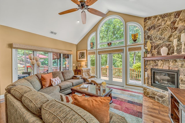 480 Winding Waters Dr, Moneta, VA 24121 - living area featuring wood finished floors, a ceiling fan, high vaulted ceiling, a stone fireplace, and healthy amount of natural light