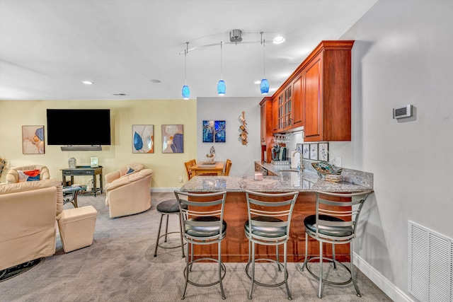 480 Winding Waters Dr, Moneta, VA 24121 - kitchen featuring a sink, light stone counters, a peninsula, a breakfast bar area, and brown cabinets