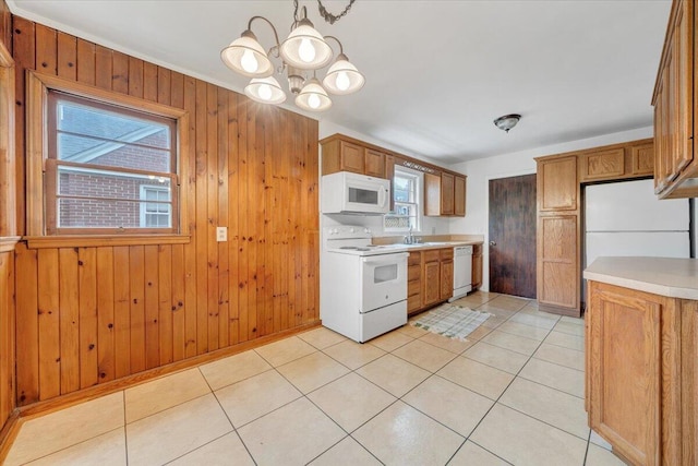 1113 Brandon Ave SW, Roanoke, VA 24015 - kitchen featuring white appliances, light countertops, a chandelier, wooden walls, and brown cabinets