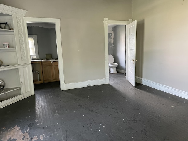 832 Patterson Ave SW, Roanoke, VA 24016 - unfurnished bedroom featuring baseboards, dark wood-style floors, and ensuite bath