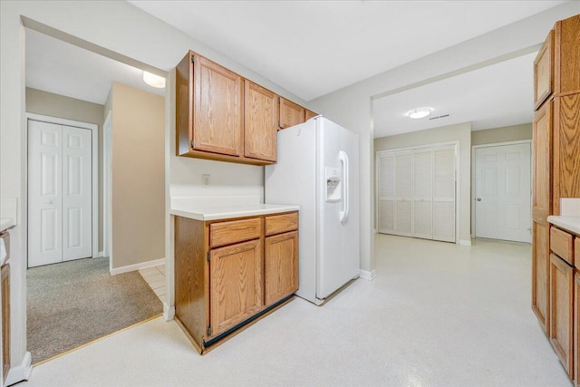 8506 Pine Hurst Cir, Roanoke, VA 24019 - kitchen featuring white refrigerator with ice dispenser, light countertops, baseboards, light carpet, and brown cabinetry