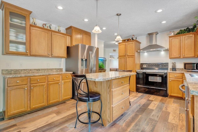 384 White Oak Ln, New Castle, VA 24127 - kitchen featuring stainless steel appliances, wall chimney range hood, a kitchen island, light wood-style flooring, and a textured ceiling