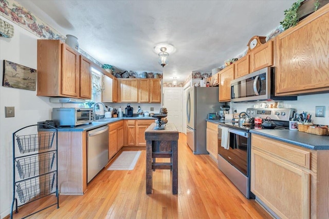 6119 Carolina Trl, Roanoke, VA 24019 - kitchen with appliances with stainless steel finishes, light wood-style flooring, a sink, and dark countertops
