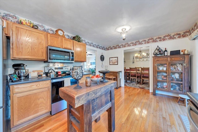 6119 Carolina Trl, Roanoke, VA 24019 - kitchen featuring appliances with stainless steel finishes, light wood-type flooring, a chandelier, and dark countertops