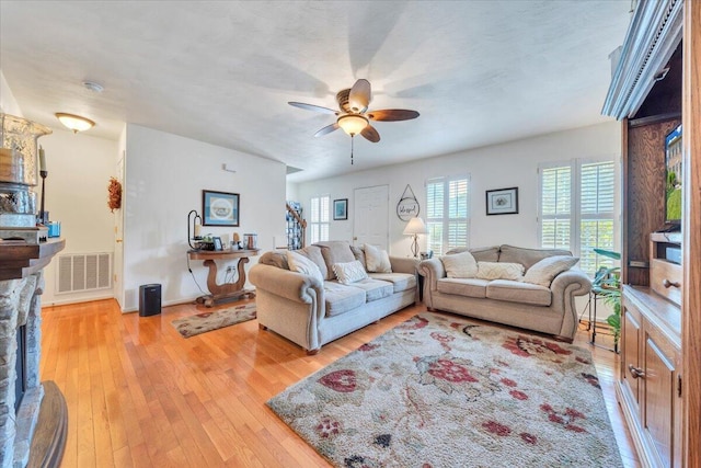 6119 Carolina Trl, Roanoke, VA 24019 - living area with light wood-type flooring, a ceiling fan, and a stone fireplace