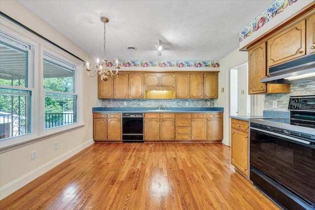 1207 Laymantown Rd, Troutville, VA 24175 - kitchen with black appliances, under cabinet range hood, a sink, brown cabinets, and a textured ceiling