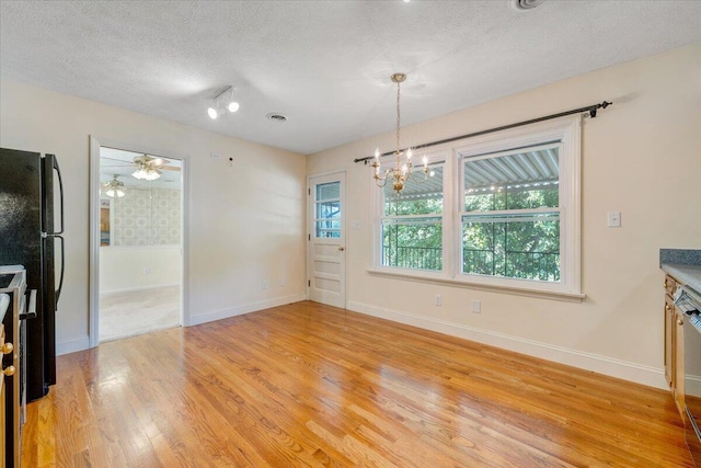 1207 Laymantown Rd, Troutville, VA 24175 - unfurnished dining area with a chandelier, light wood finished floors, a textured ceiling, and baseboards