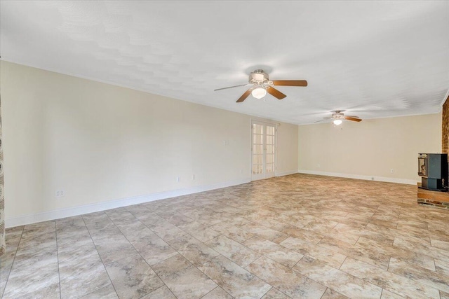 1207 Laymantown Rd, Troutville, VA 24175 - unfurnished living room with a ceiling fan, a wood stove, and baseboards