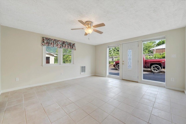 1207 Laymantown Rd, Troutville, VA 24175 - spare room featuring a textured ceiling, healthy amount of natural light, a ceiling fan, light tile patterned flooring, and baseboards