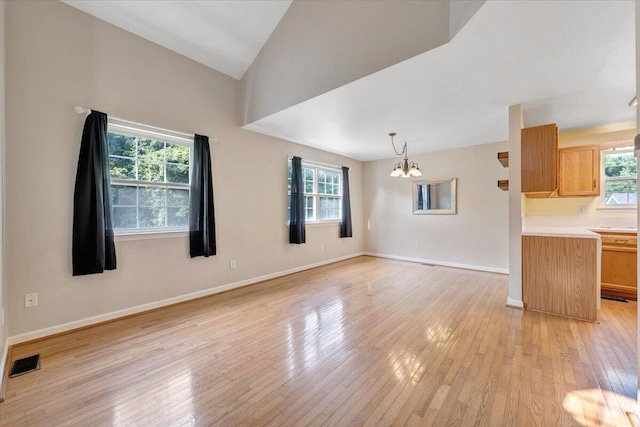 715 N Stonewall St, Salem, VA 24153 - unfurnished living room with a chandelier, healthy amount of natural light, light wood finished floors, and lofted ceiling