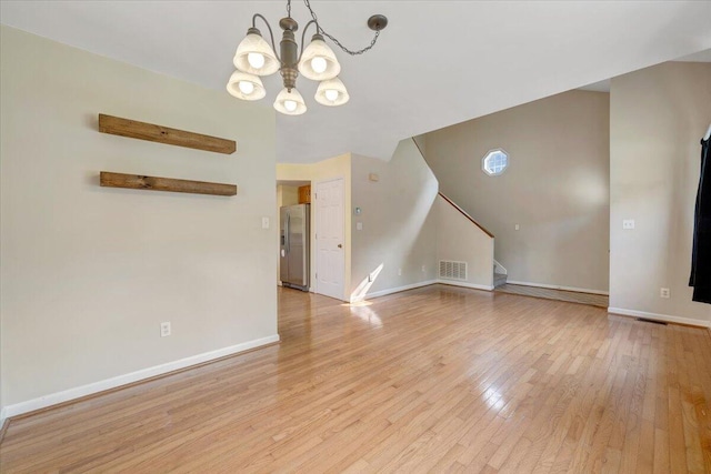 715 N Stonewall St, Salem, VA 24153 - unfurnished living room with stairs, a chandelier, and light wood finished floors