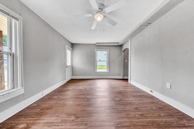 1002 Stewart Ave SE, Roanoke, VA 24013 - empty room featuring arched walkways, a ceiling fan, wood finished floors, and baseboards