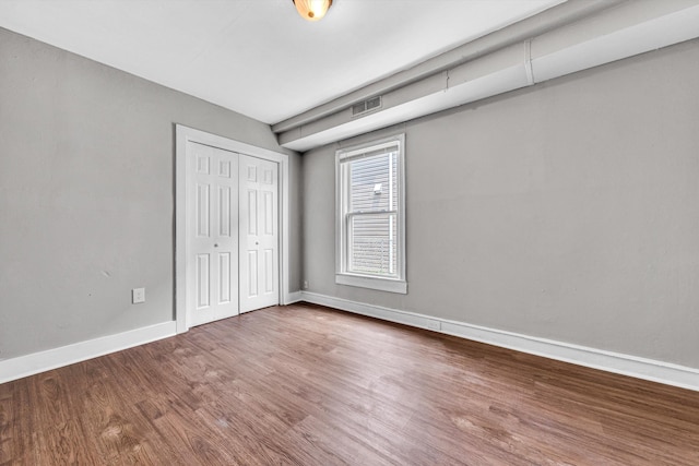 1002 Stewart Ave SE, Roanoke, VA 24013 - unfurnished bedroom with wood finished floors, a closet, and baseboards