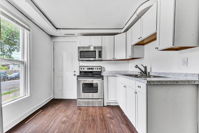 1002 Stewart Ave SE, Roanoke, VA 24013 - kitchen featuring stainless steel appliances, a sink, dark wood-type flooring, light countertops, and white cabinetry